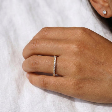 Soft portrait of a woman wearing a moissanite sterling silver full eternity band in 18k yellow gold plating - Sensitive Stones