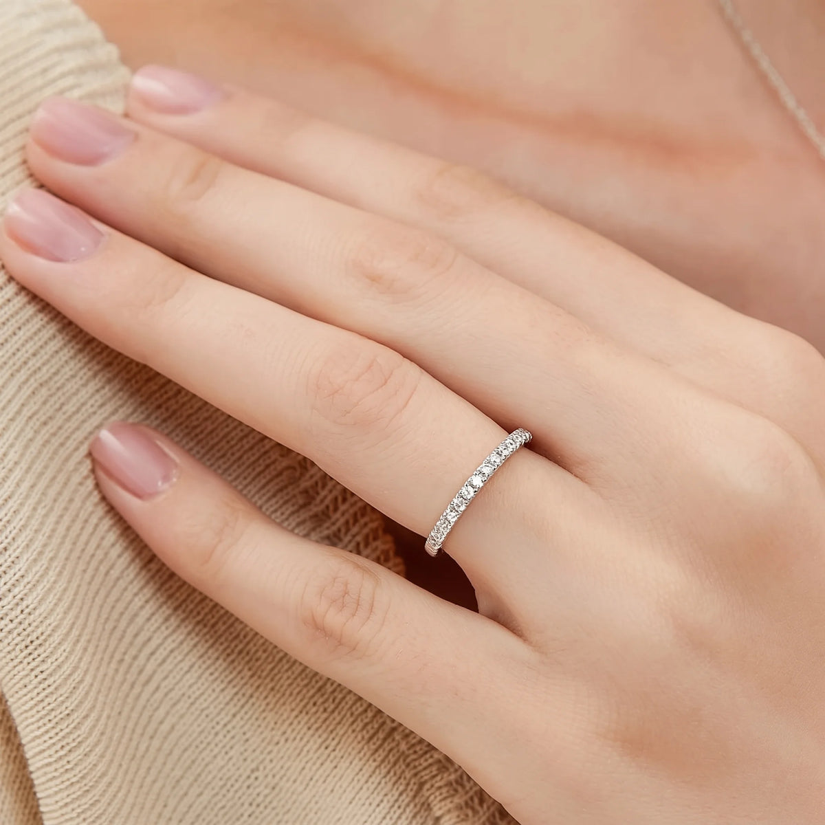 Close-up of a hand wearing the moissanite half eternity ring in 925 sterling silver - Sensitive Stones