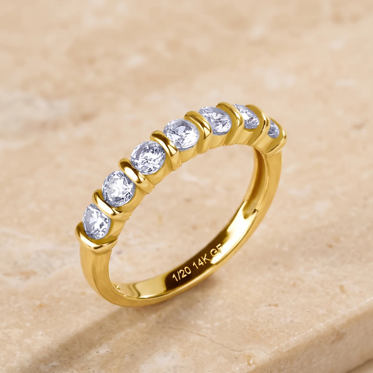 14K gold filled moissanite half eternity ring in yellow gold on a stone surface, 1/20 14K GF stamp visible - Sensitive Stones