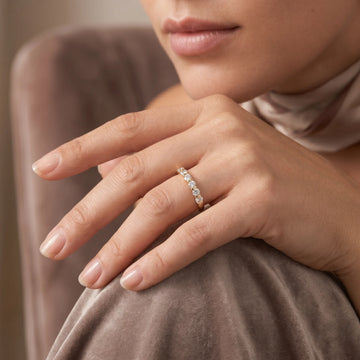 14K gold filled moissanite half eternity ring in yellow gold worn on the ring finger, lifestyle portrait - Sensitive Stones