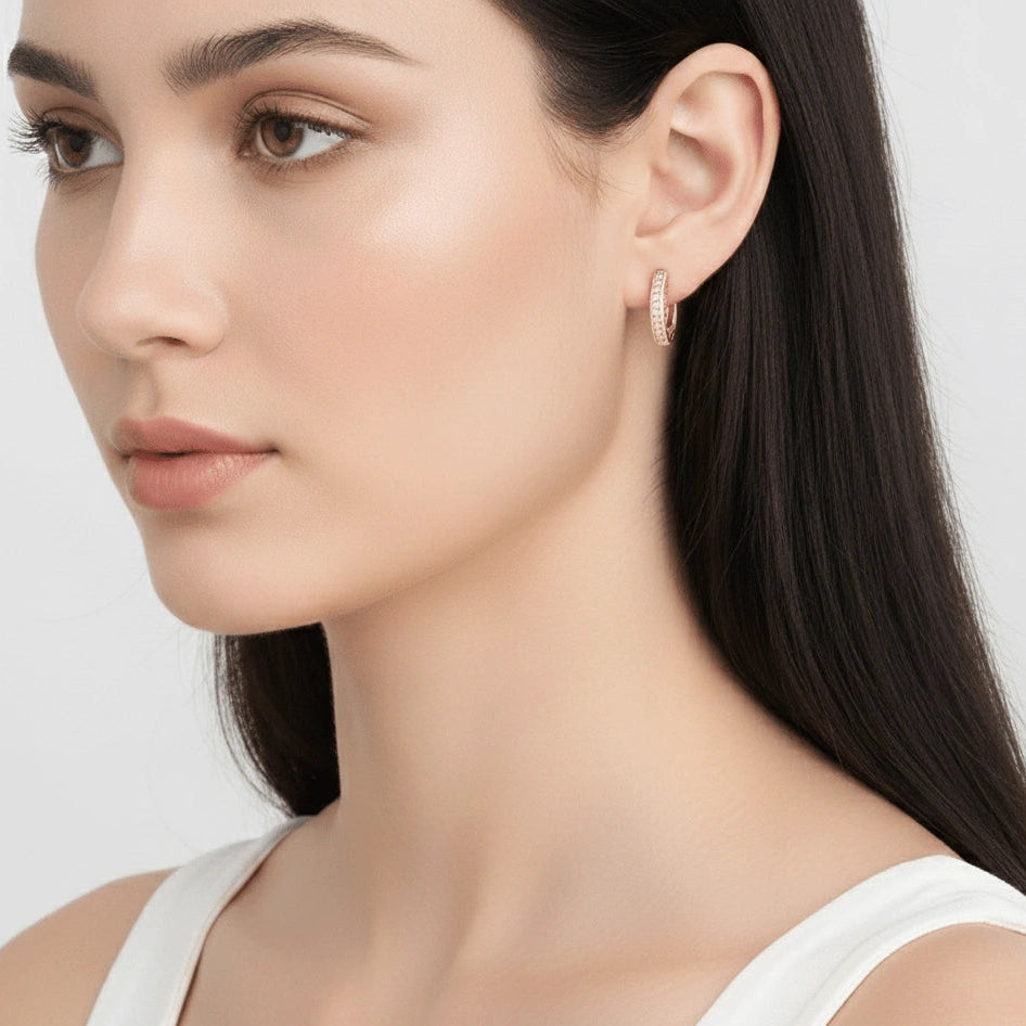 Close-up of a woman wearing a moissanite huggie hoop earring in a rose gold finish showing the 15mm hoop sitting close to the lobe - Sensitive Stones