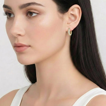 Close-up of a woman wearing a moissanite huggie hoop earring in a yellow gold finish showing the 15mm hoop sitting close to the lobe - Sensitive Stones