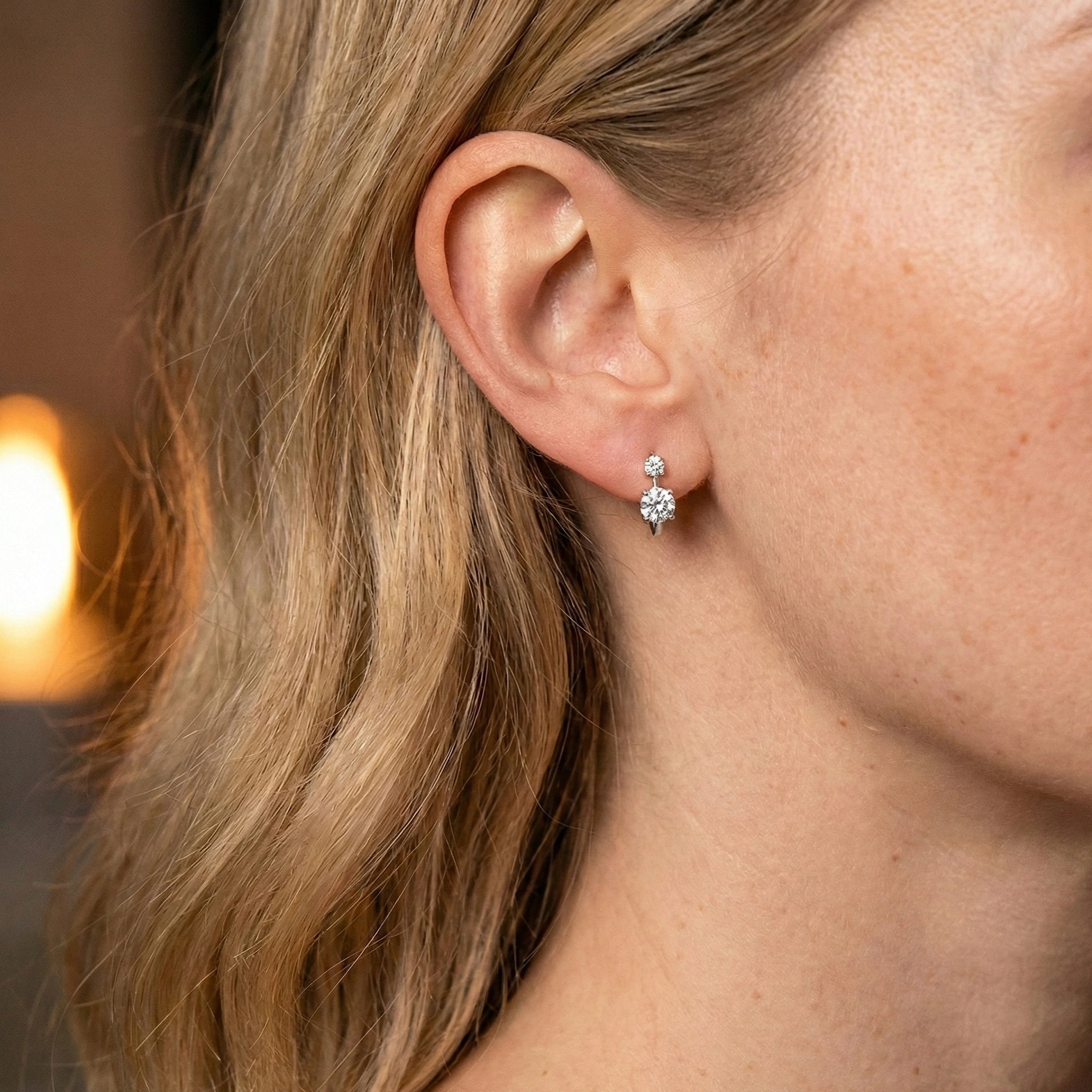 Woman wearing double stone moissanite huggie hoop earrings white gold 12mm diameter - Sensitive Stones