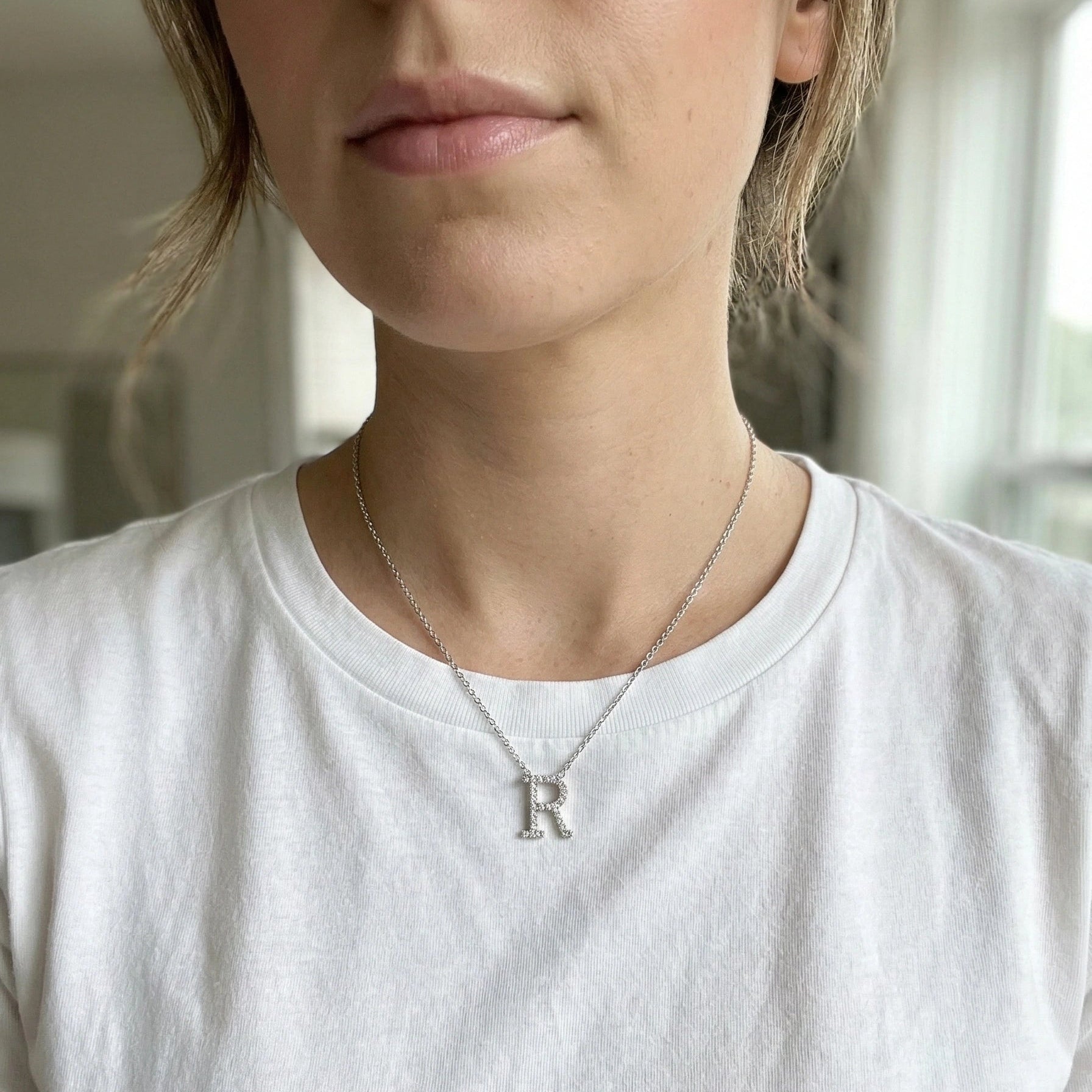 Moissanite initial necklace letter R worn by model white t-shirt indoor natural light - Sensitive Stones
