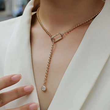 Moissanite Y-shape lariat necklace in 18K yellow gold worn over white blazer with bezel-set drop pendant — Sensitive Stones