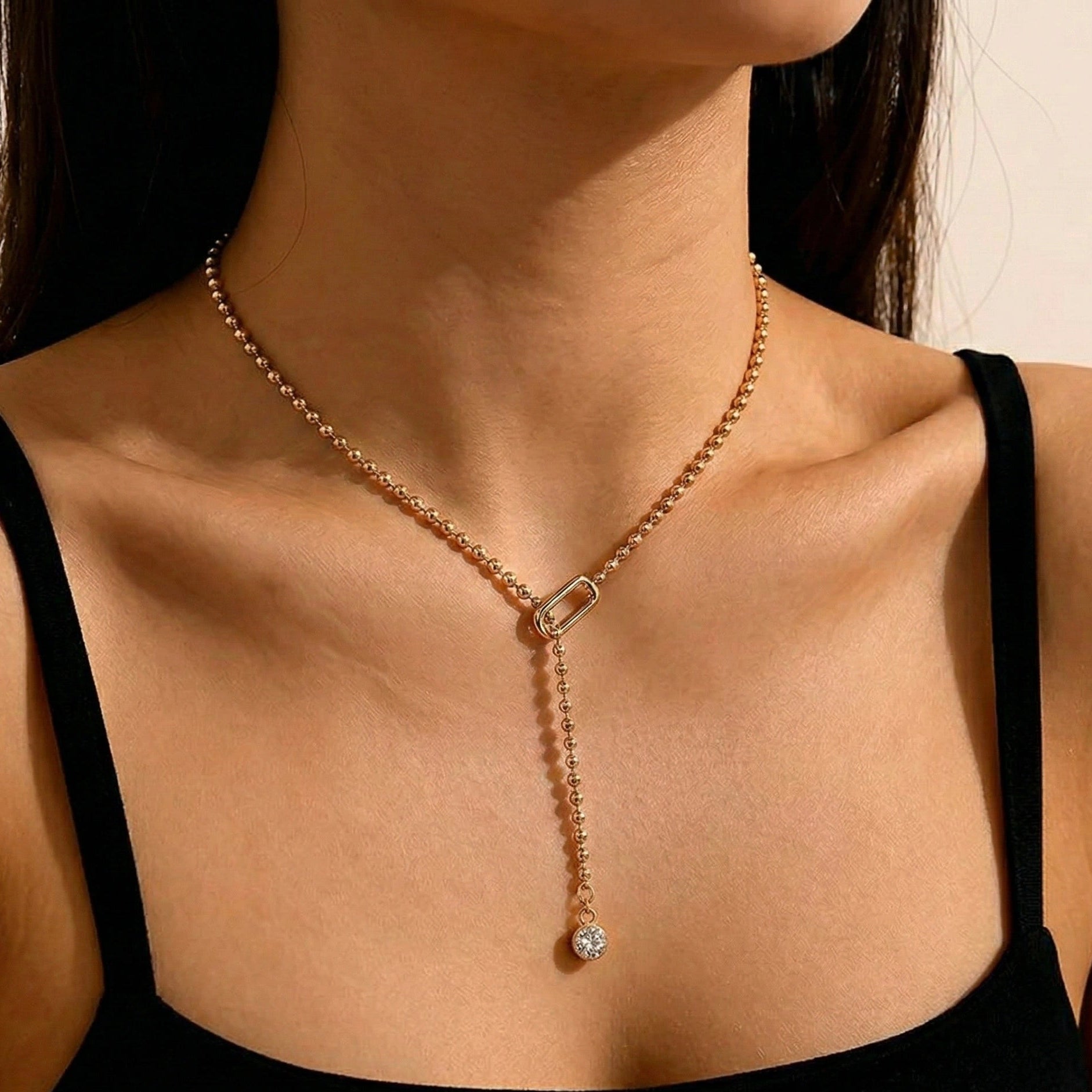 Gold bead chain moissanite lariat necklace with bezel-set round drop pendant worn with black top — Sensitive Stones