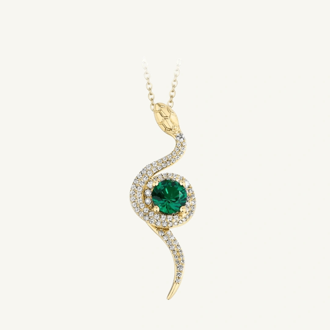 Serpent's eye pendant necklace with a vivid lab emerald in the center on a beige background - Sensitive Stones