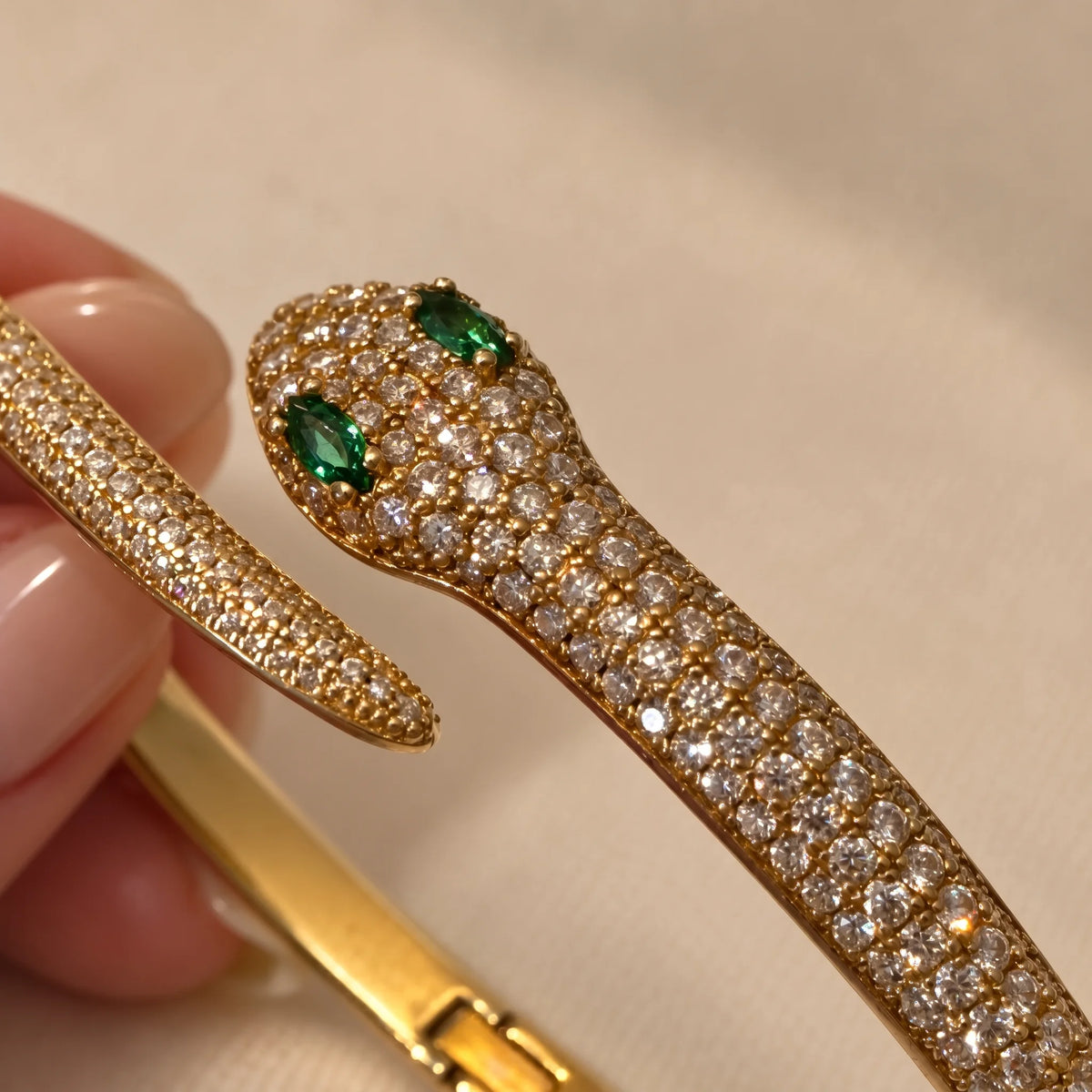 Close-up of the moissanite snake bracelet in a yellow gold finish, showing the claw-set marquise lab-created emerald eyes and rows of pavé moissanite - Sensitive Stones