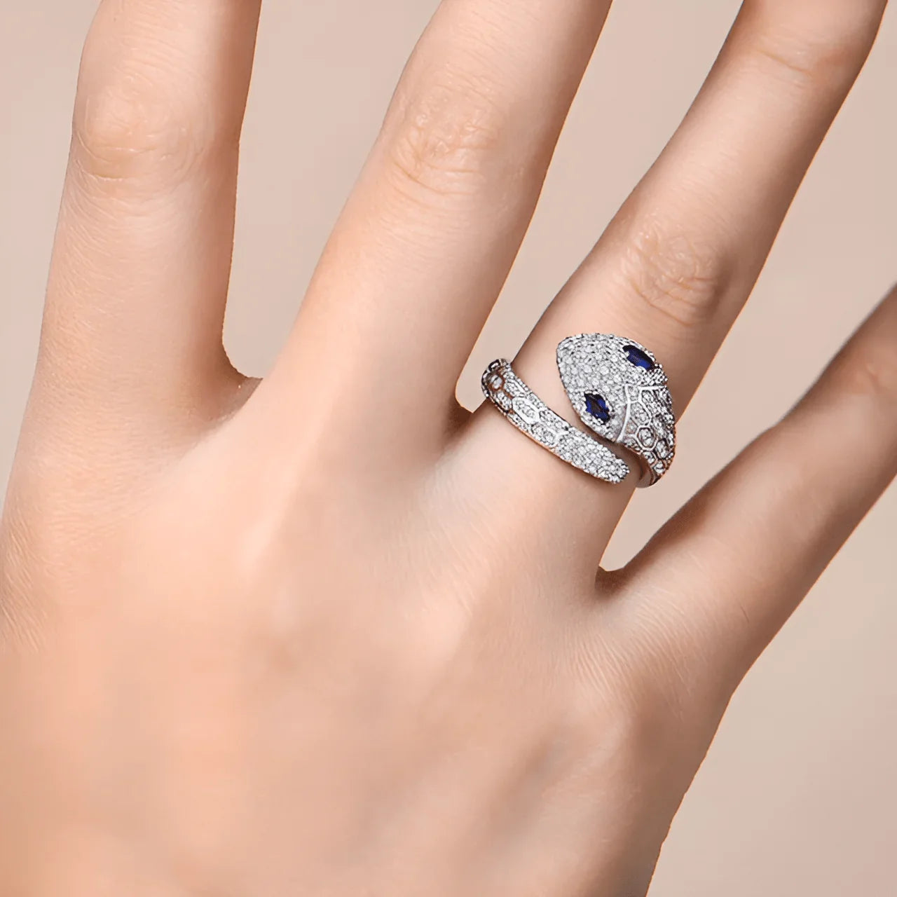 Woman wearing moissanite snake ring with blue gemstone eyes, white gold-plated sterling silver design | Sensitive Stones