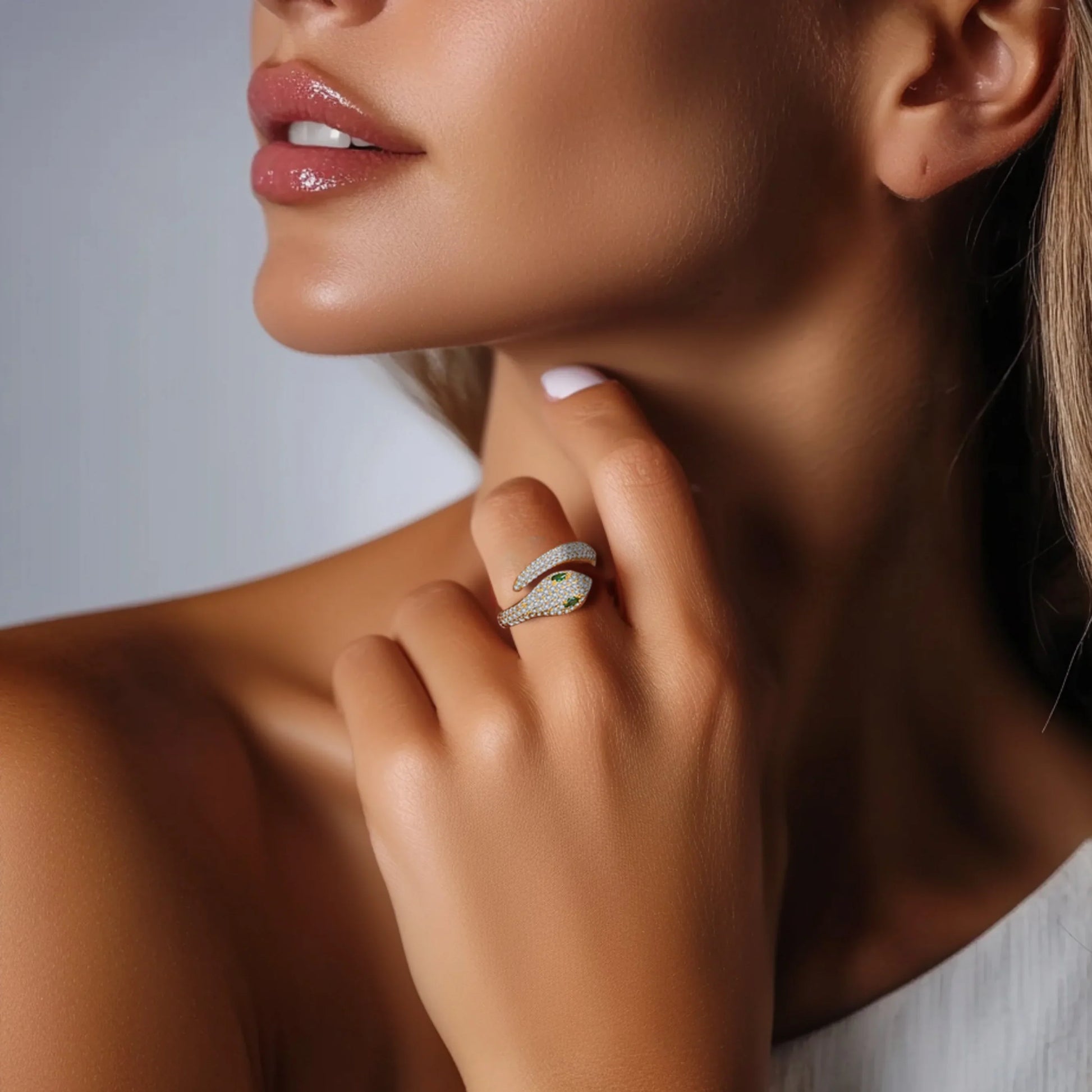 Woman wearing gold plated 925 silver moissanite snake ring with green gemstone eyes, elegant serpent jewelry | Sensitive Stones