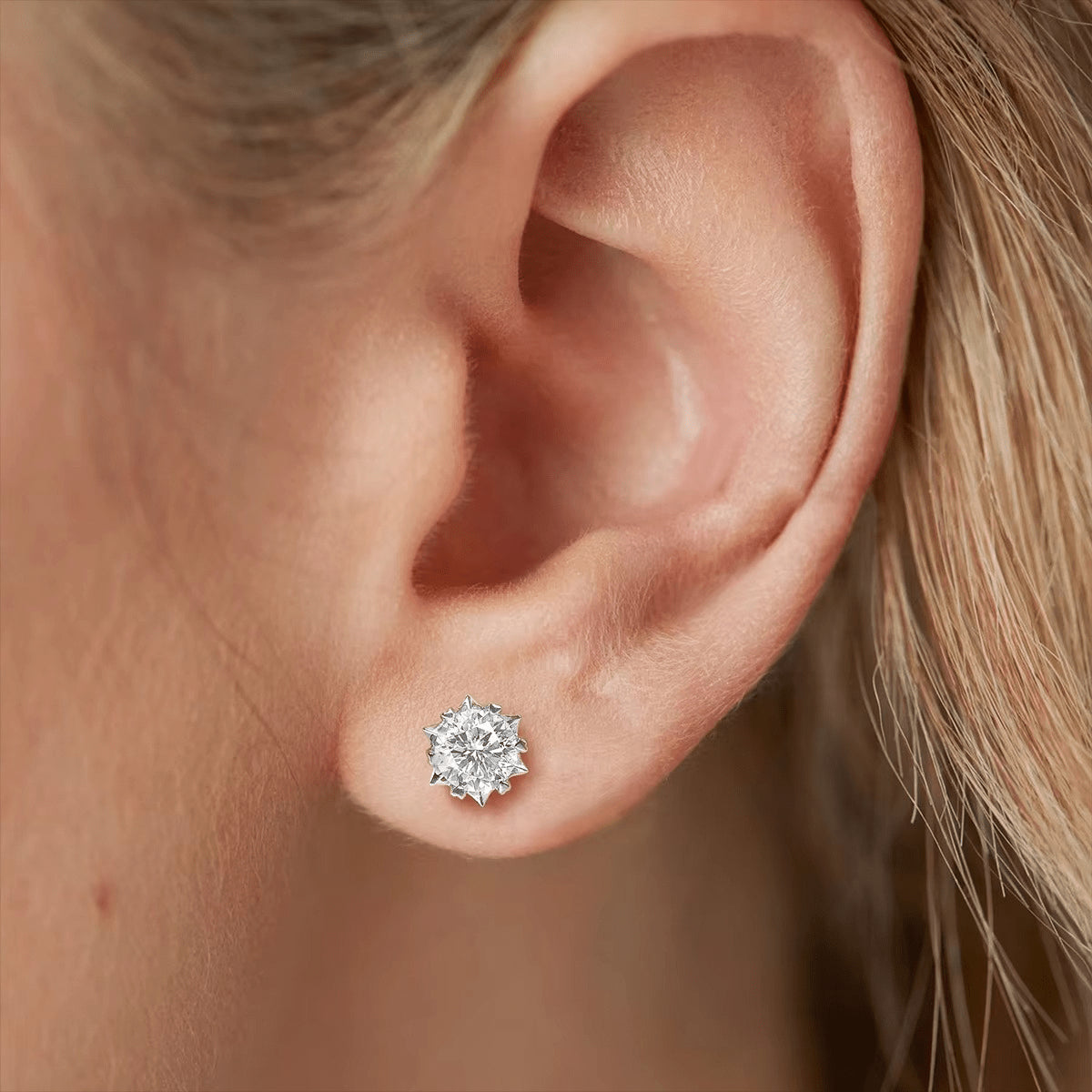Close-up of a woman wearing a snowflake-shaped moissanite stud earring, capturing winter-inspired elegance and the brilliance of the stone - Sensitive Stones