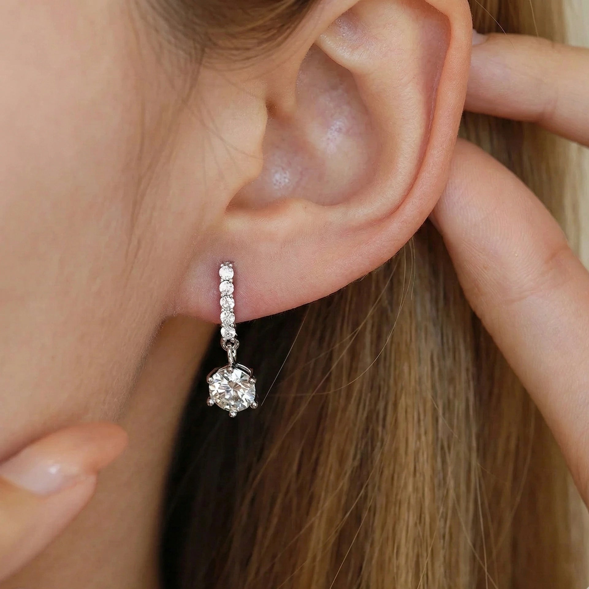 Moissanite solitaire drop earrings with pavé accent bar in 925 sterling silver worn on ear lifestyle close-up shot - Sensitive Stones