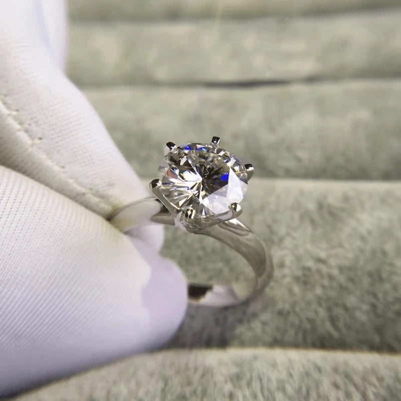  Classic moissanite solitaire ring held in white glove close up - Sensitive Stones