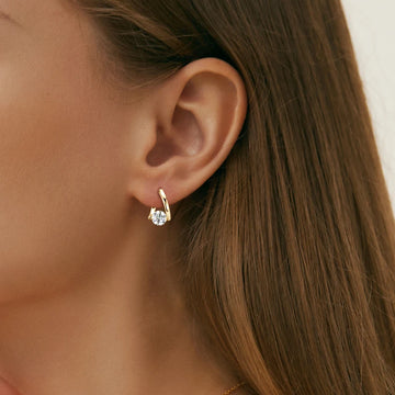 Closeup of model wearing gold plated Moissanite Solitaire Twist Hoop Earrings 925 sterling silver for everyday sparkle - Sensitve Stones