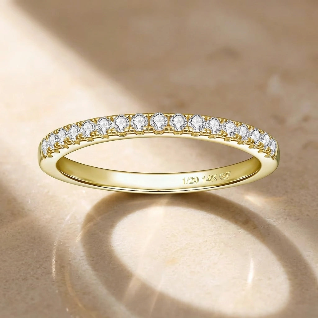 Moissanite stackable ring in 14K gold filled, a thin half eternity band of prong-set stones with the 1/20 14K GF stamp inside, on a warm stone surface - Sensitive Stones