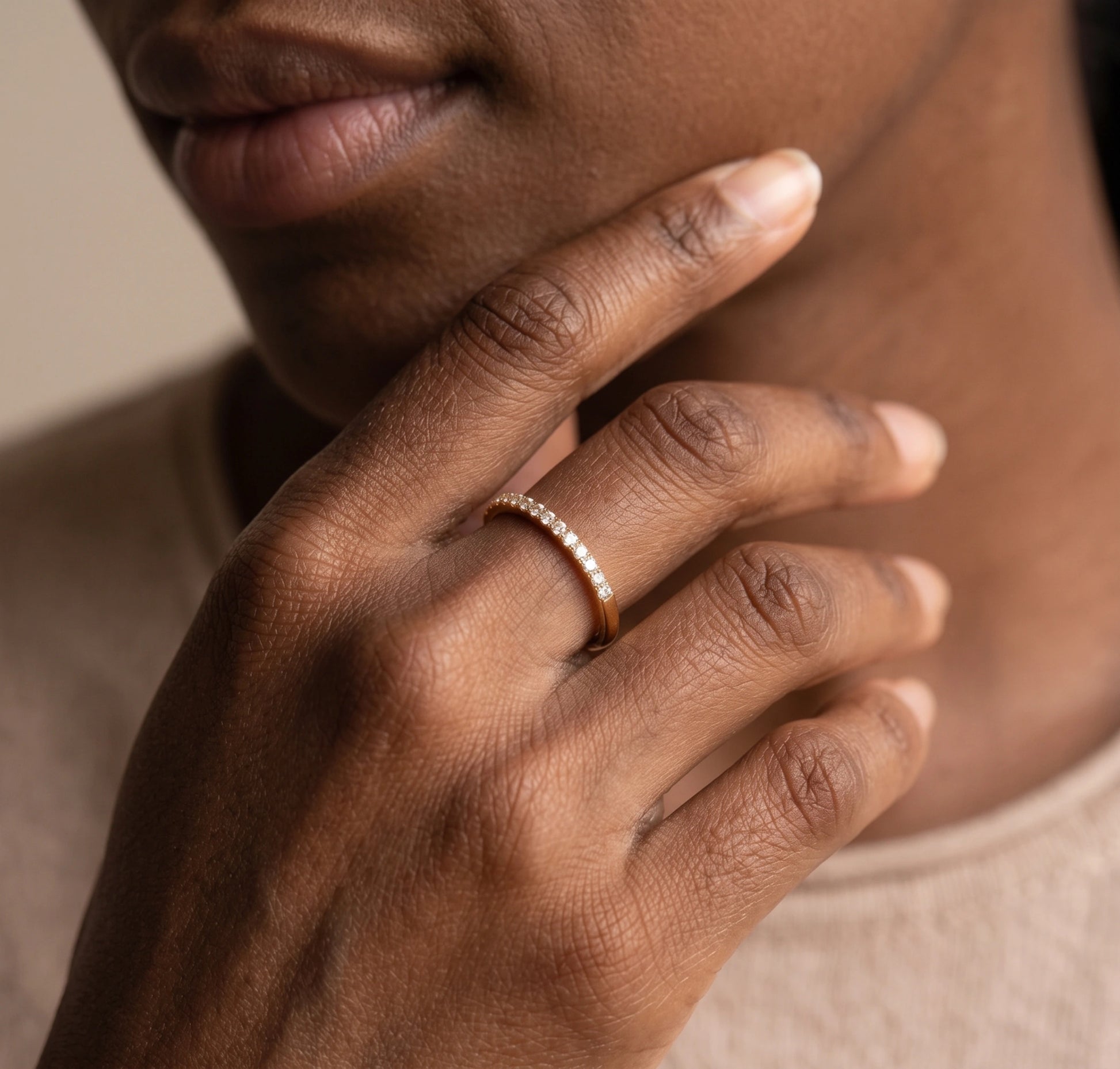 Close-up of a woman wearing the moissanite stackable ring in 14K gold filled, hand resting at her chin - Sensitive Stones