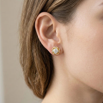Woman wearing 1ct moissanite swirl flower stud earring in 18K gold plated 925 sterling silver with cubic zirconia pavé accents - Sensitive Stones