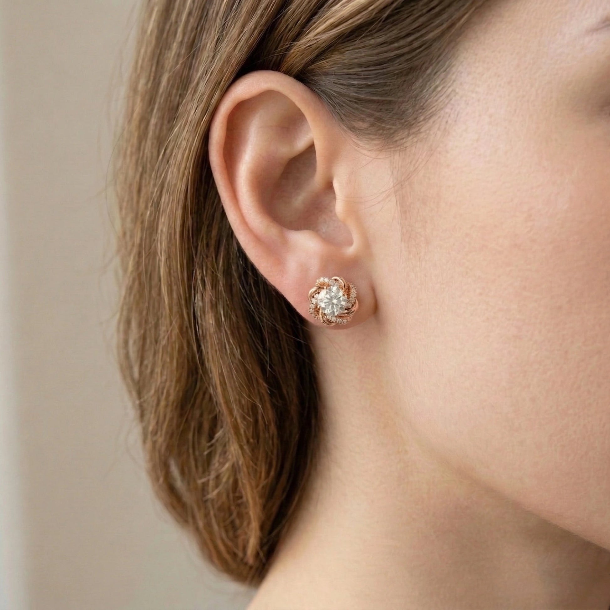 Woman wearing 1ct moissanite swirl flower stud earring in rose gold plated 925 sterling silver with cubic zirconia pavé accents - Sensitive Stones