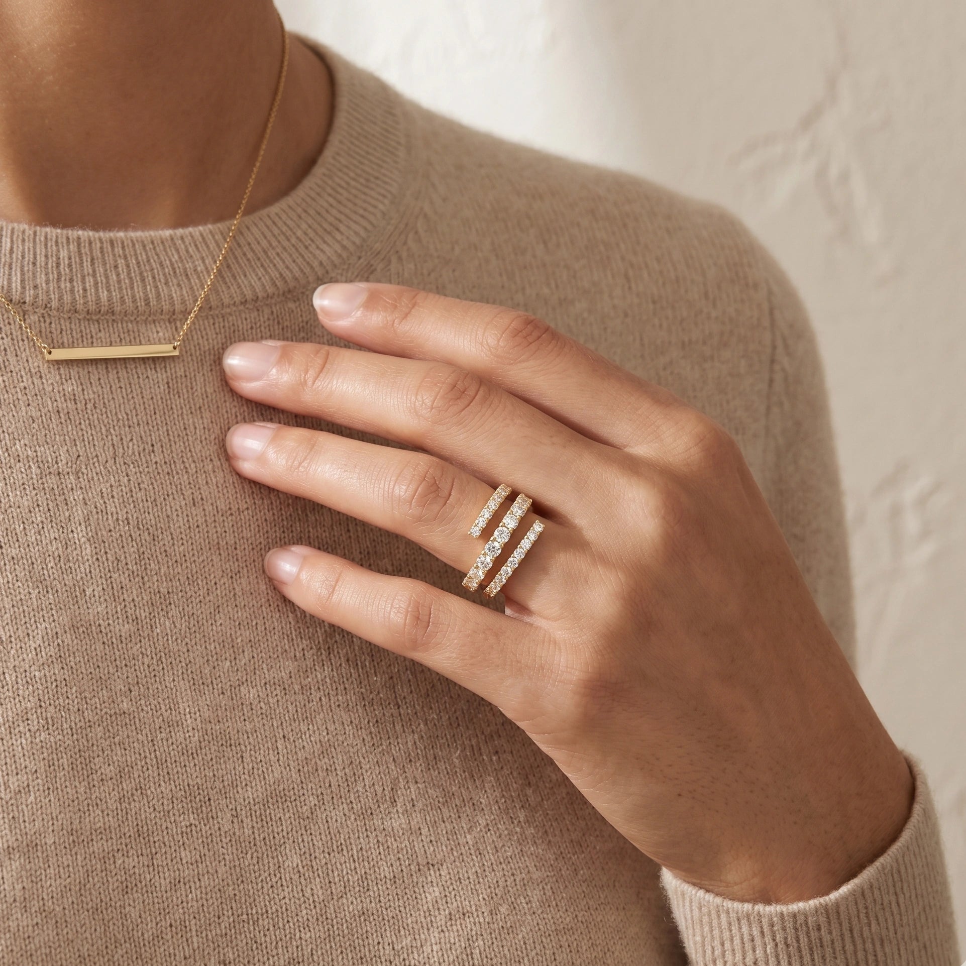 Moissanite triple wrap spiral ring in yellow gold styled with simple necklace and sweater - Sensitive Stones