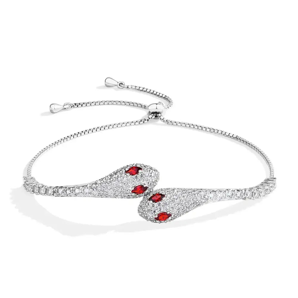Moissanite twin snake bracelet in 925 sterling silver with a white gold finish showing two pave serpent heads with red cubic zirconia eyes - Sensitive Stones