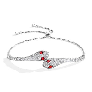 Moissanite twin snake bracelet in 925 sterling silver with a white gold finish showing two pave serpent heads with red cubic zirconia eyes - Sensitive Stones