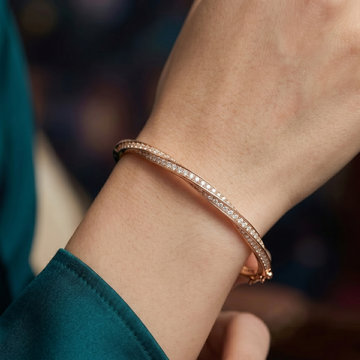 Woman wearing moissanite twist bangle in 18K rose gold plated 925 silver on wrist - Sensitive Stones