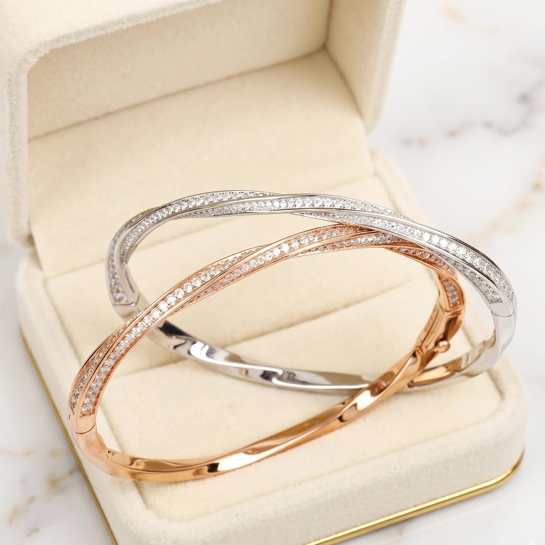 Moissanite twist bangle in rose gold and white gold variants displayed in velvet jewelry box - Sensitive Stones