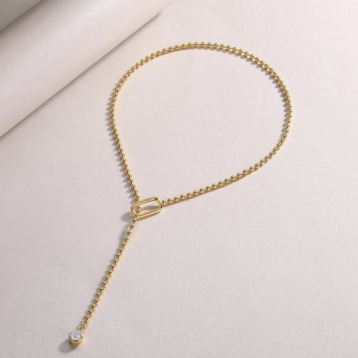 Flat-lay of Moissanite Y-Shape Necklace on white background showing gold-plated chain and bezel-set drop – Sensitive Stones