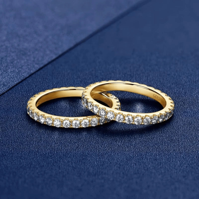  Two yellow gold moissanite full eternity rings stacked on navy background - Sensitive Stones