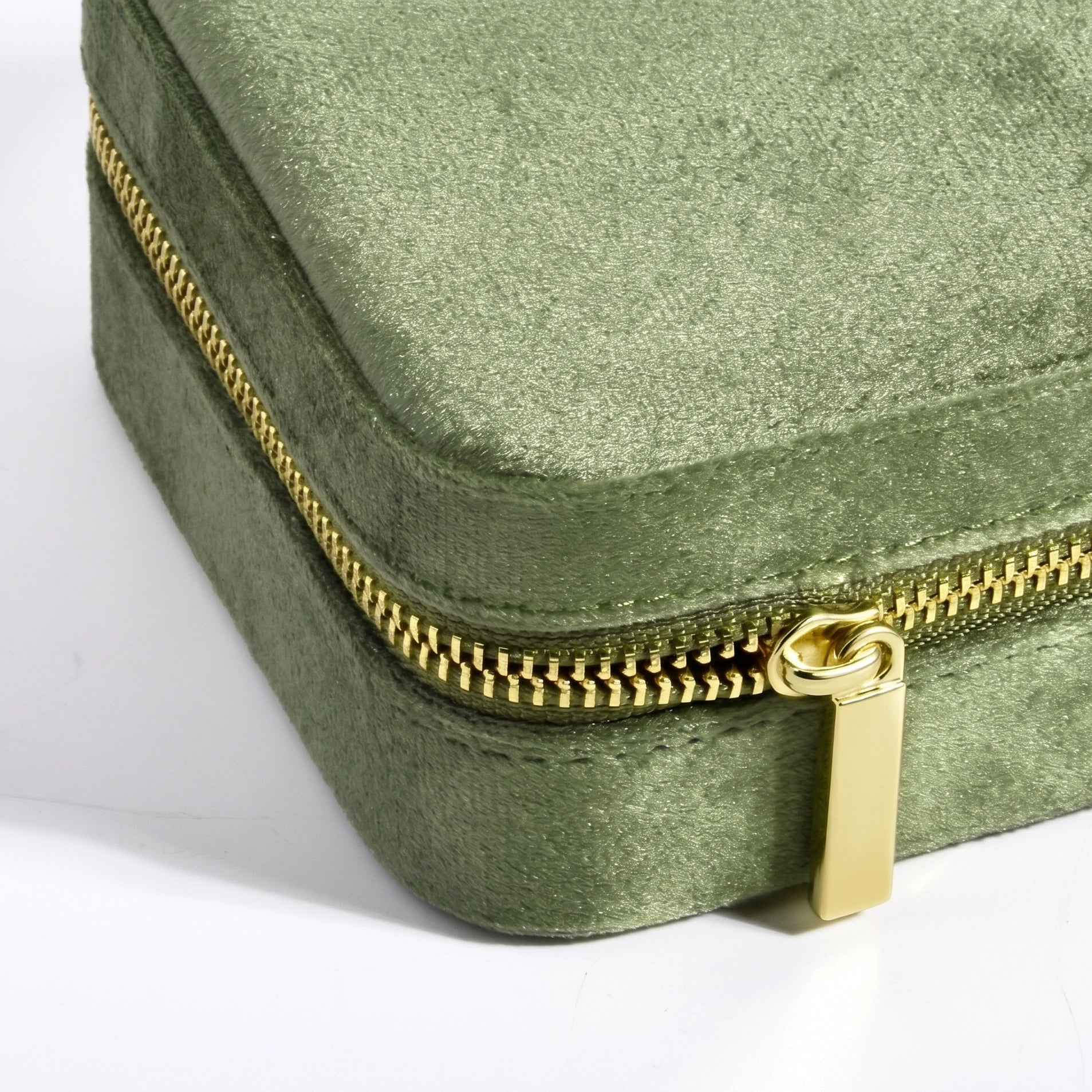 Close up of smooth copper zipper on olive green velvet travel jewelry box - Sensitive Stones