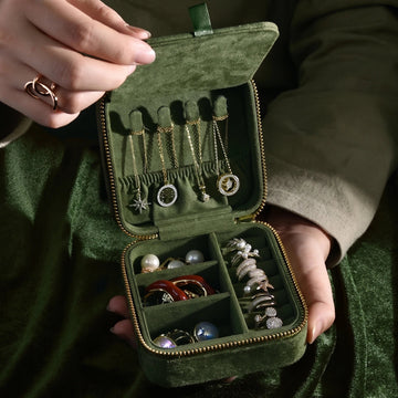 Olive green velvet travel jewelry box held open showing necklace hooks with gold necklaces and rings stored in compartments - Sensitive Stones