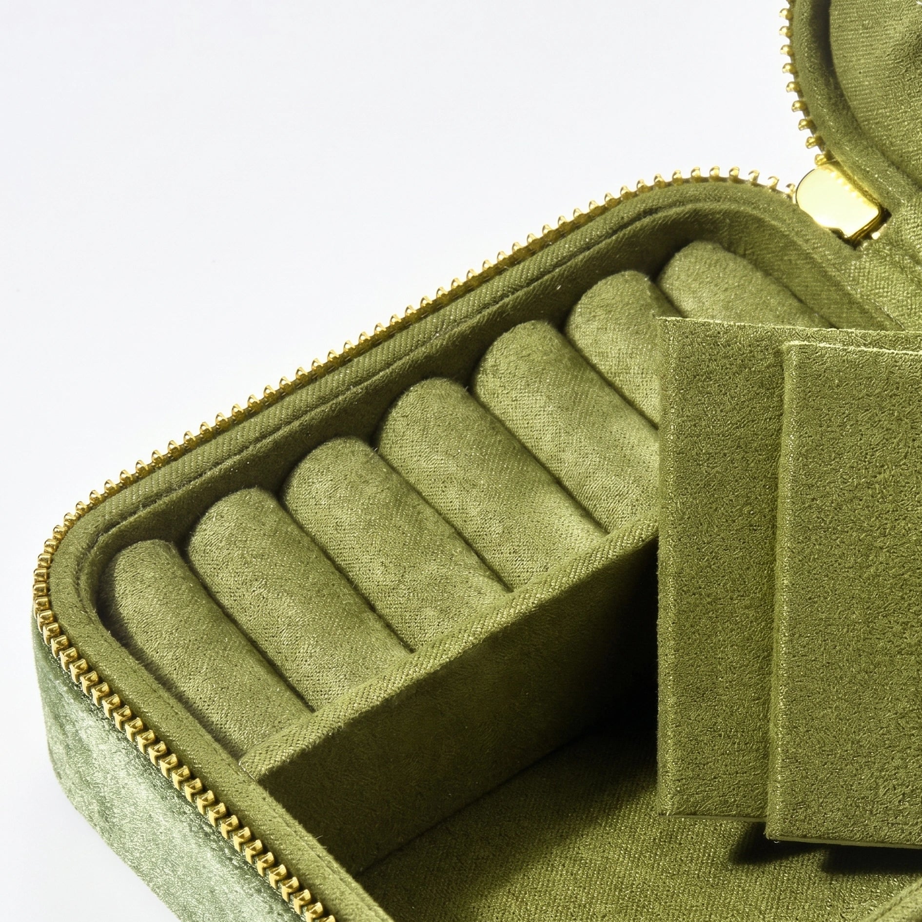 Interior of olive green velvet travel jewelry box showing ring rolls and earring compartments - Sensitive Stones
