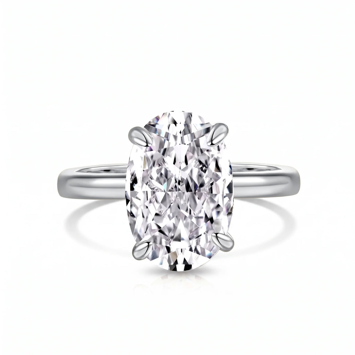 Oval cut moissanite solitaire ring in 925 sterling silver with a white gold finish on a white background showing the four prong setting - Sensitive Stones