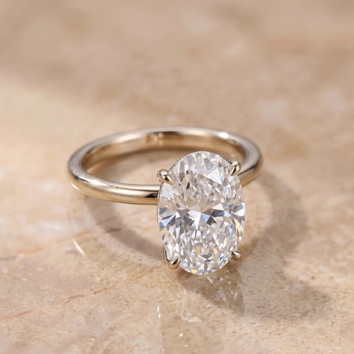 Oval cut moissanite solitaire ring in a white gold finish showing the slim band profile and four prong setting - Sensitive Stones