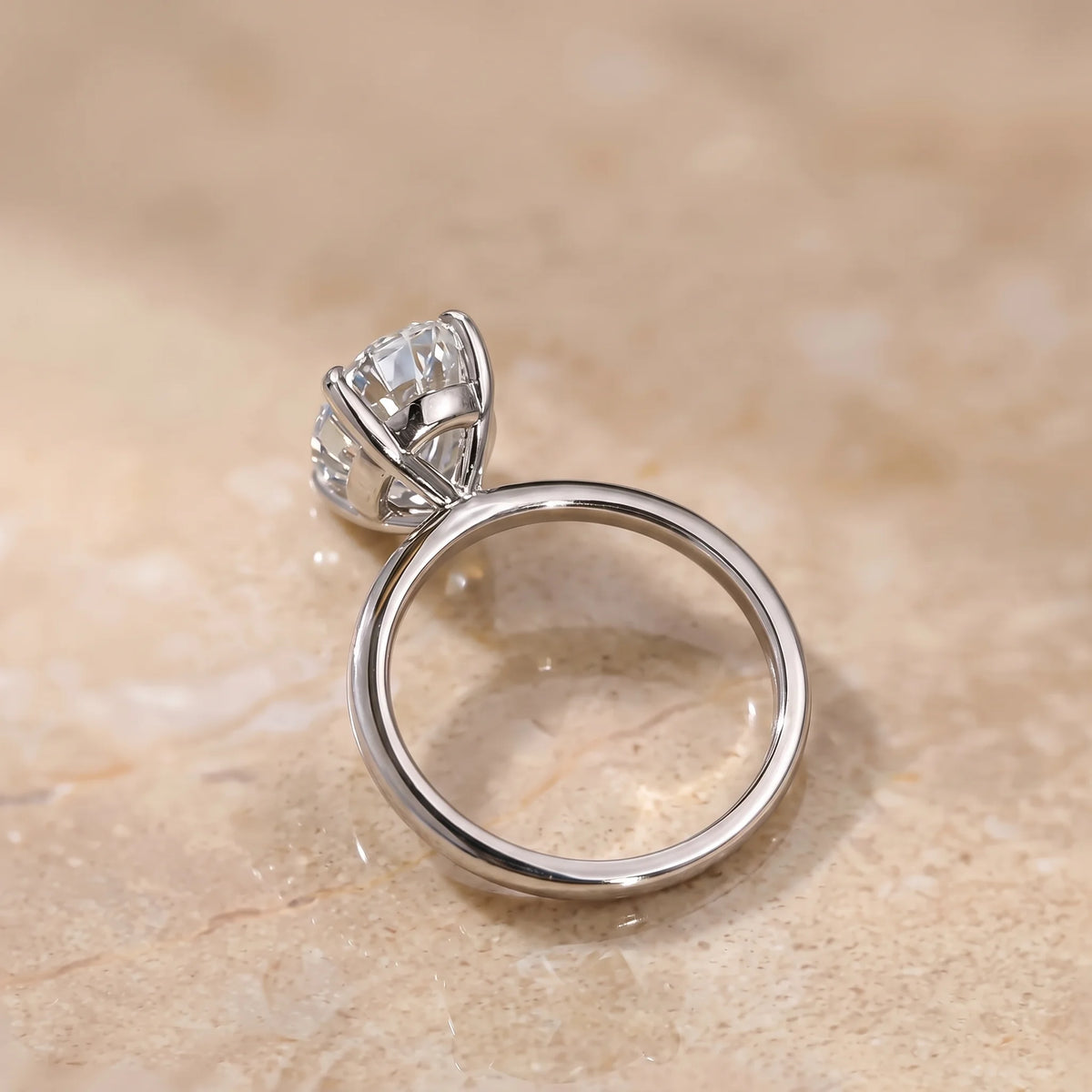 Side profile of the oval cut moissanite solitaire ring in a white gold finish showing the open gallery beneath the stone - Sensitive Stones