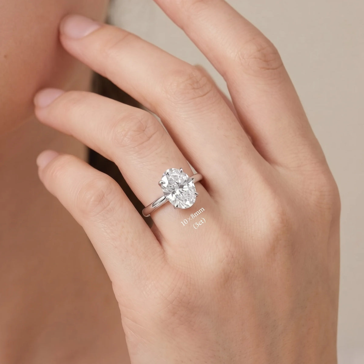Hand wearing the oval cut moissanite solitaire ring in 925 sterling silver with a white gold finish in the 10×8mm (3ct) size - Sensitive Stones