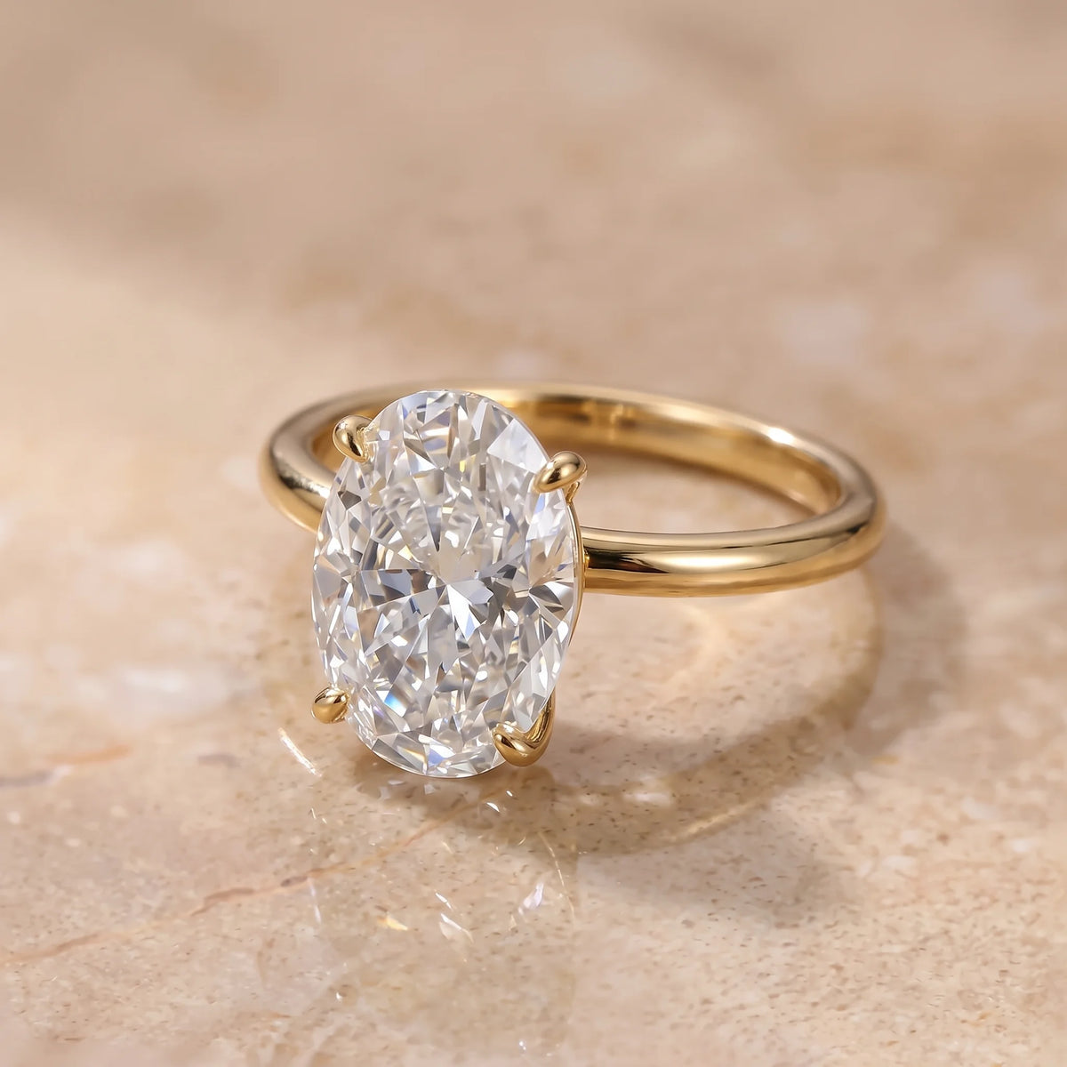 Angled view of the oval cut moissanite solitaire ring in a yellow gold finish showing the plain rounded band - Sensitive Stones