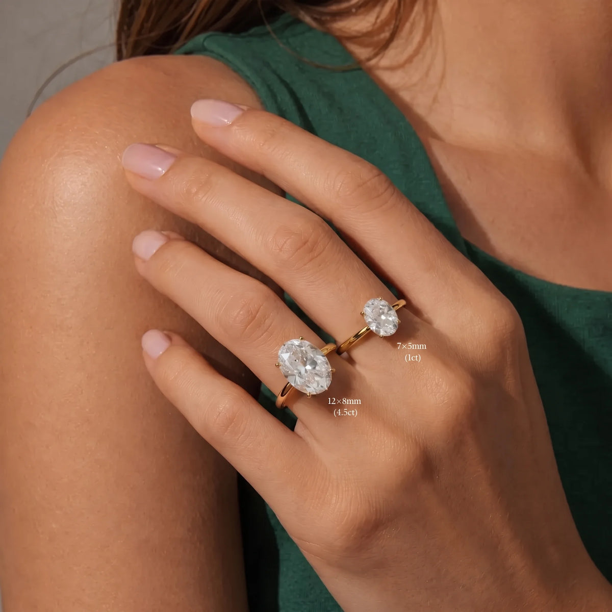 Size comparison of the oval cut moissanite solitaire ring in a yellow gold finish showing 7×5mm (1ct) beside 12×8mm (4.5ct) worn on the hand with each ring sold separately - Sensitive Stones
