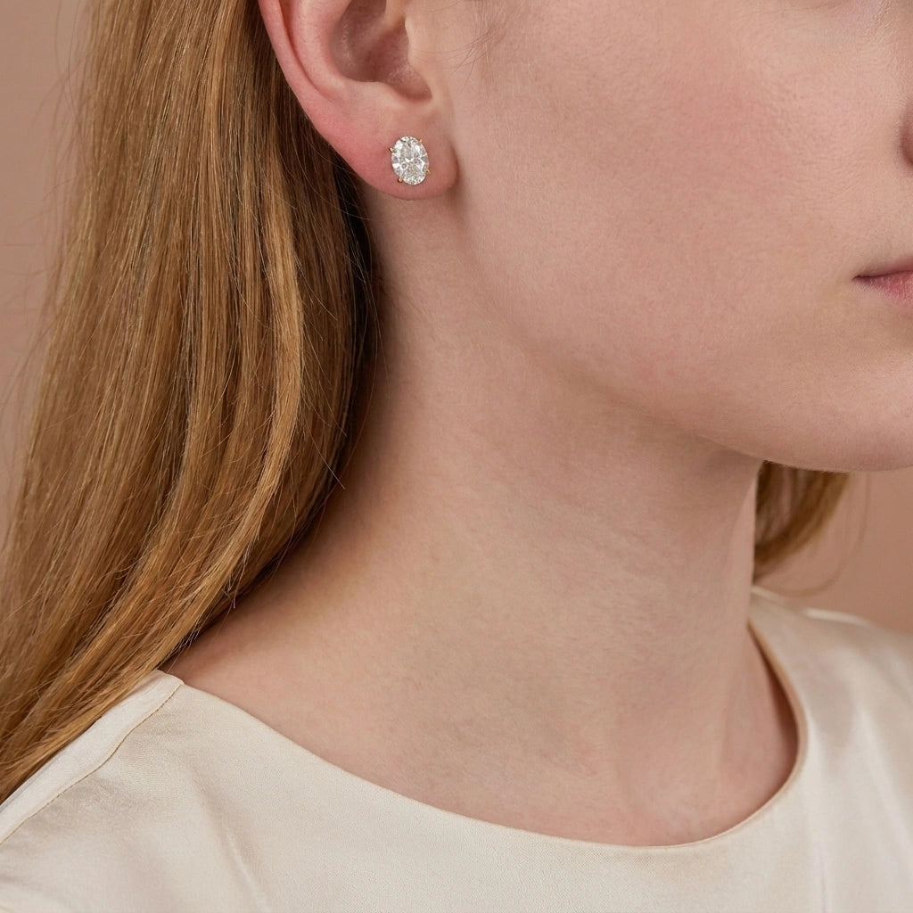 Woman wearing oval cut moissanite stud earring, 2ct with 18K yellow gold prongs - Sensitive Stones