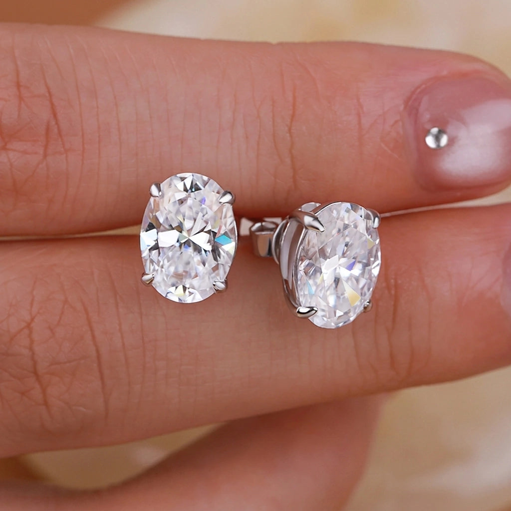Oval cut moissanite stud earrings pair held in hand - Sensitive Stones