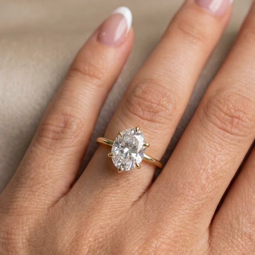 Woman wearing a 2ct oval moissanite engagement ring in 14K gold filled on her ring finger