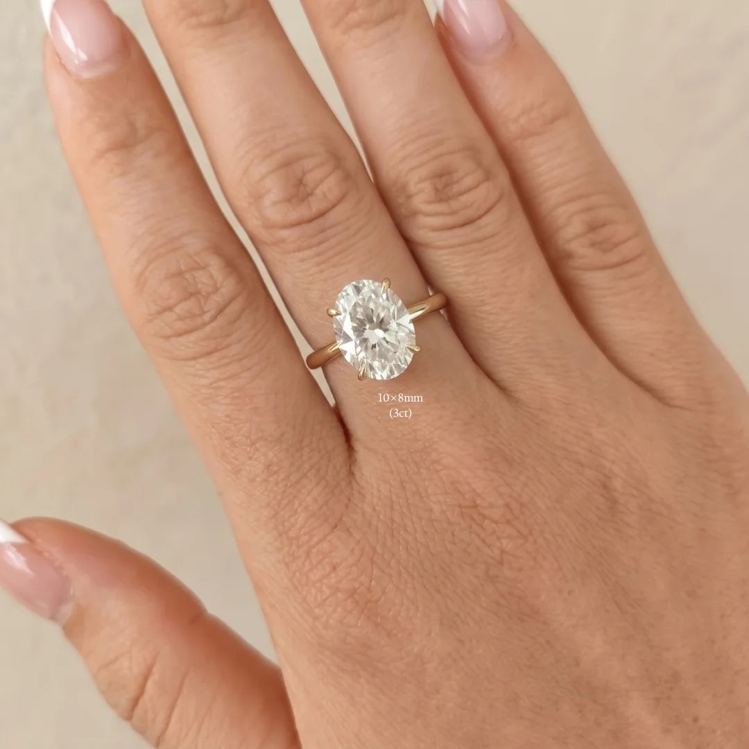 3ct oval moissanite engagement ring in 14K gold filled worn on a hand, 10x8mm stone shown for scale