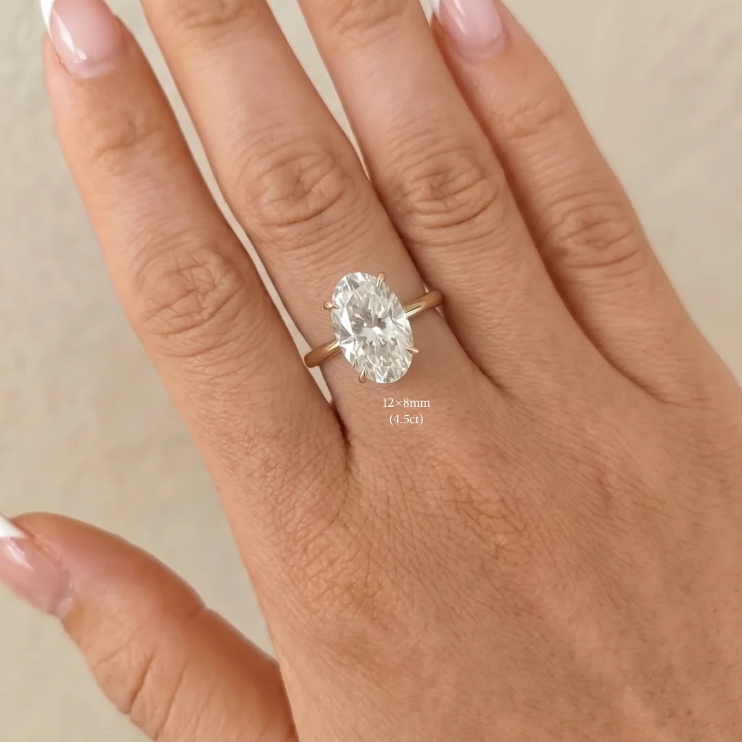 4.5ct oval moissanite engagement ring in 14K gold filled worn on a hand, 12x8mm stone shown for scale