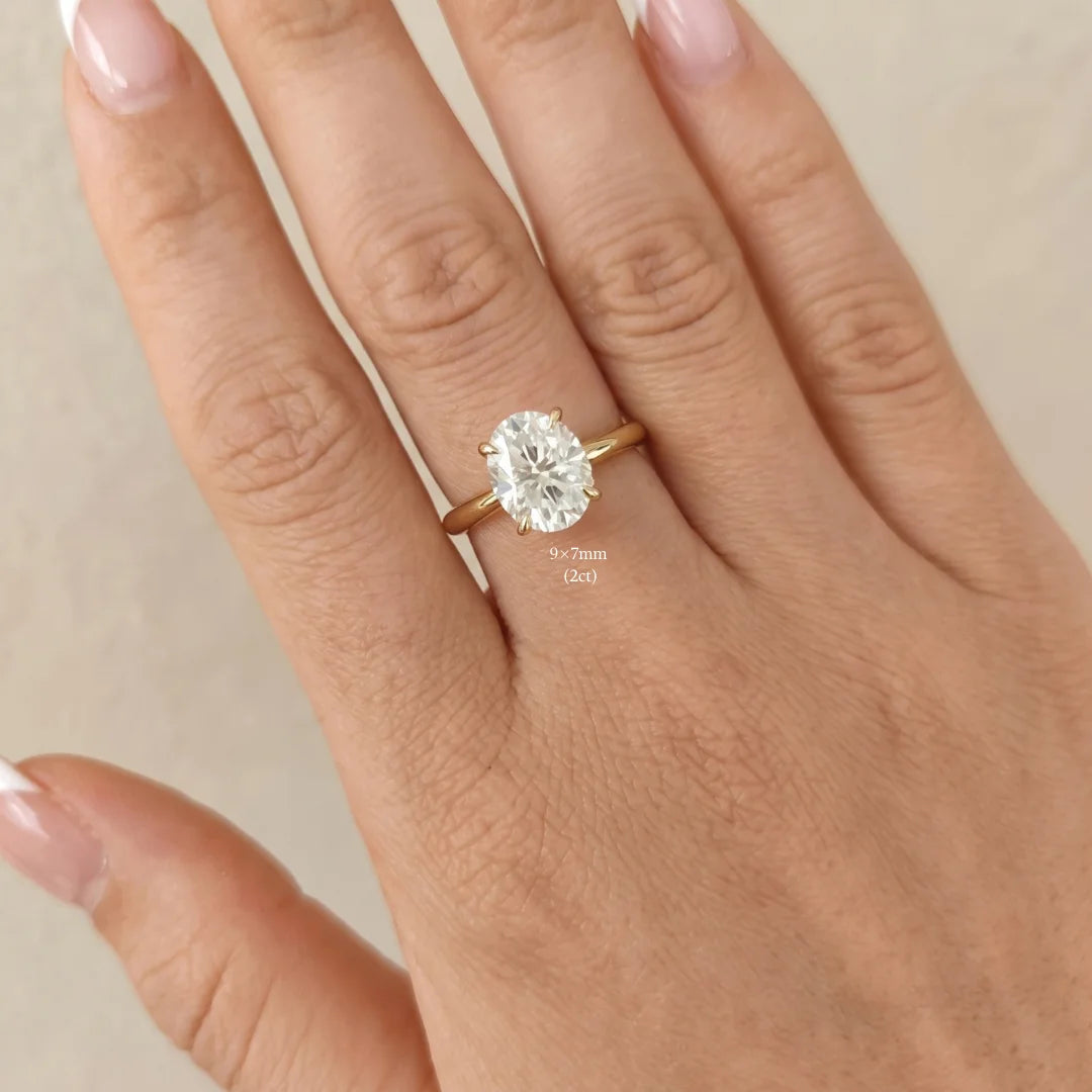 2ct oval moissanite engagement ring in 14K gold filled worn on a hand, 9x7mm stone shown for scale