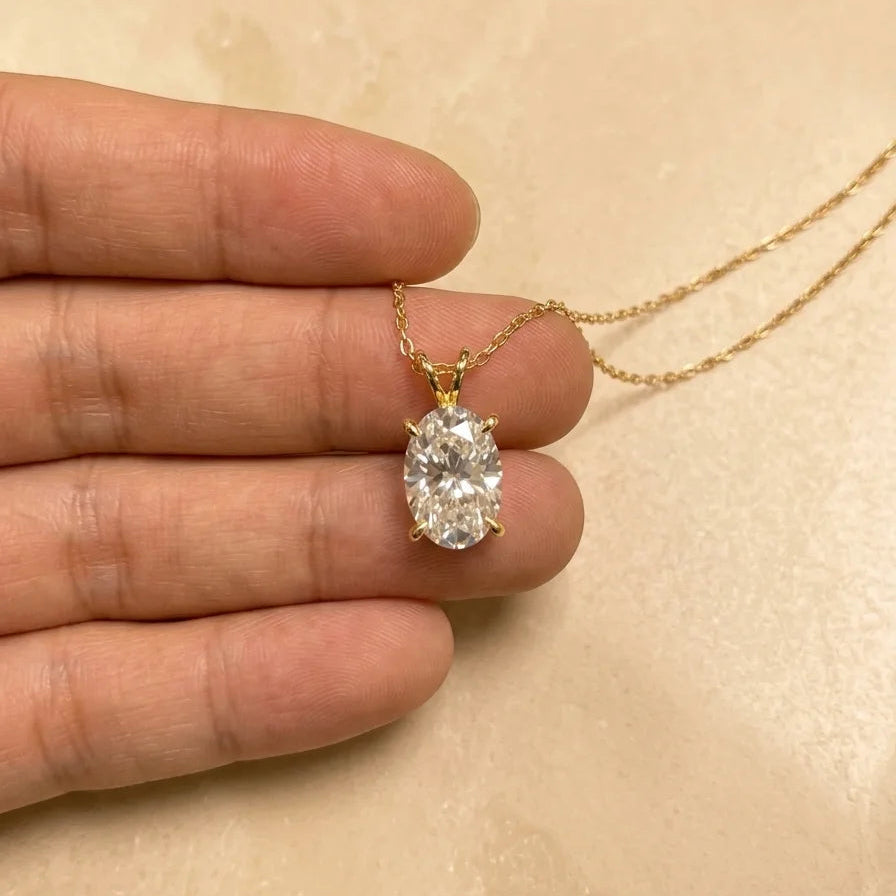 Oval moissanite pendant necklace in 14K gold filled held in the hand to show its size - Sensitive Stones