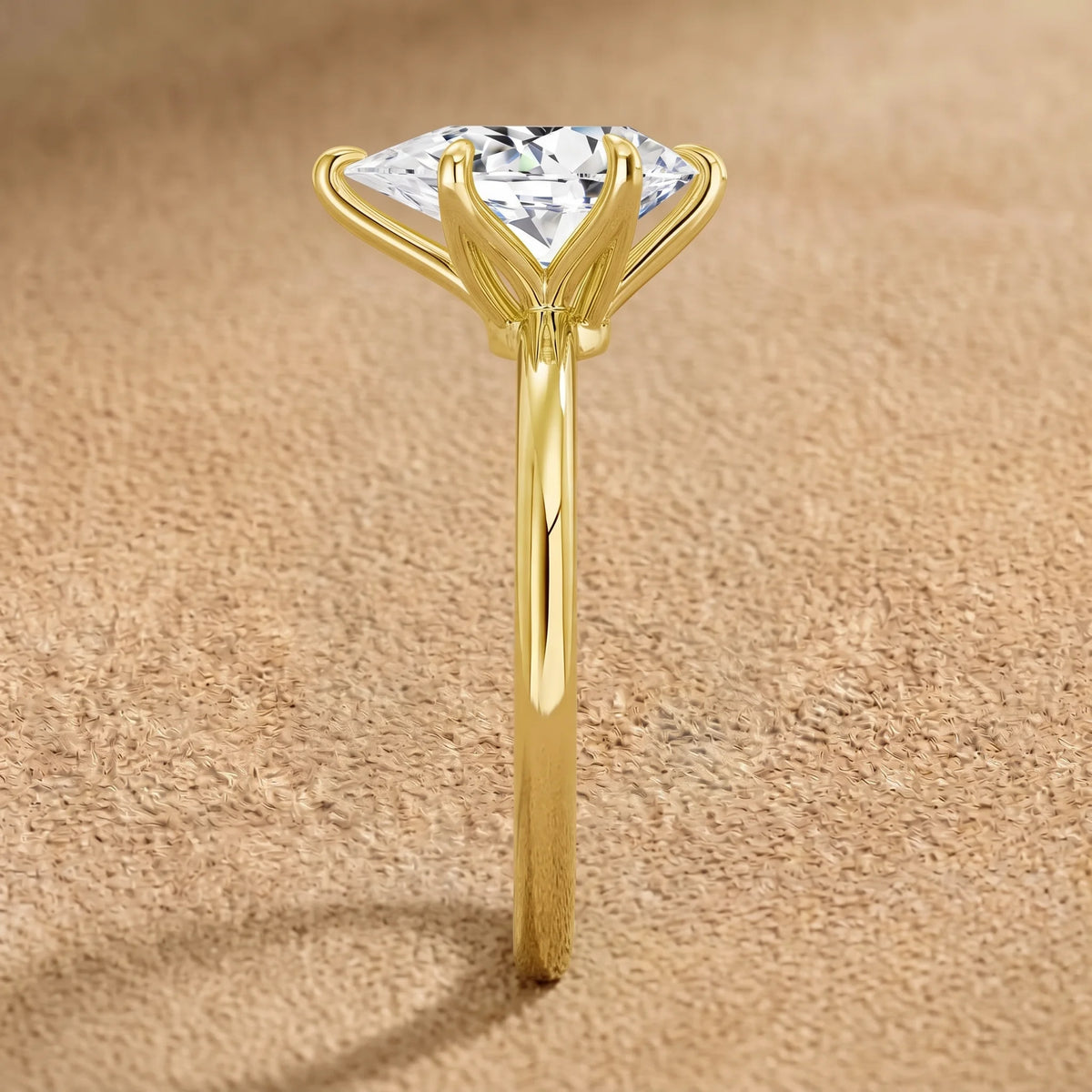 Side view of a pear cut moissanite engagement ring in 14K gold filled, showing the six-prong basket with a V-prong capping the point - Sensitive Stones