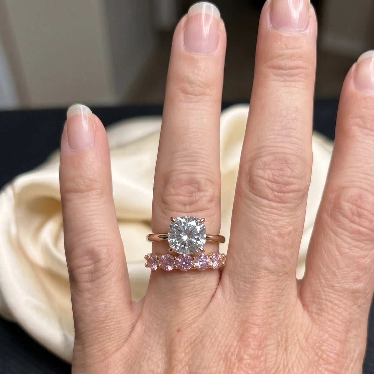 Pink moissanite five stone stackable ring in 14K gold filled worn stacked beneath a solitaire engagement ring, showing how the slim band sits flush - Sensitive Stones
