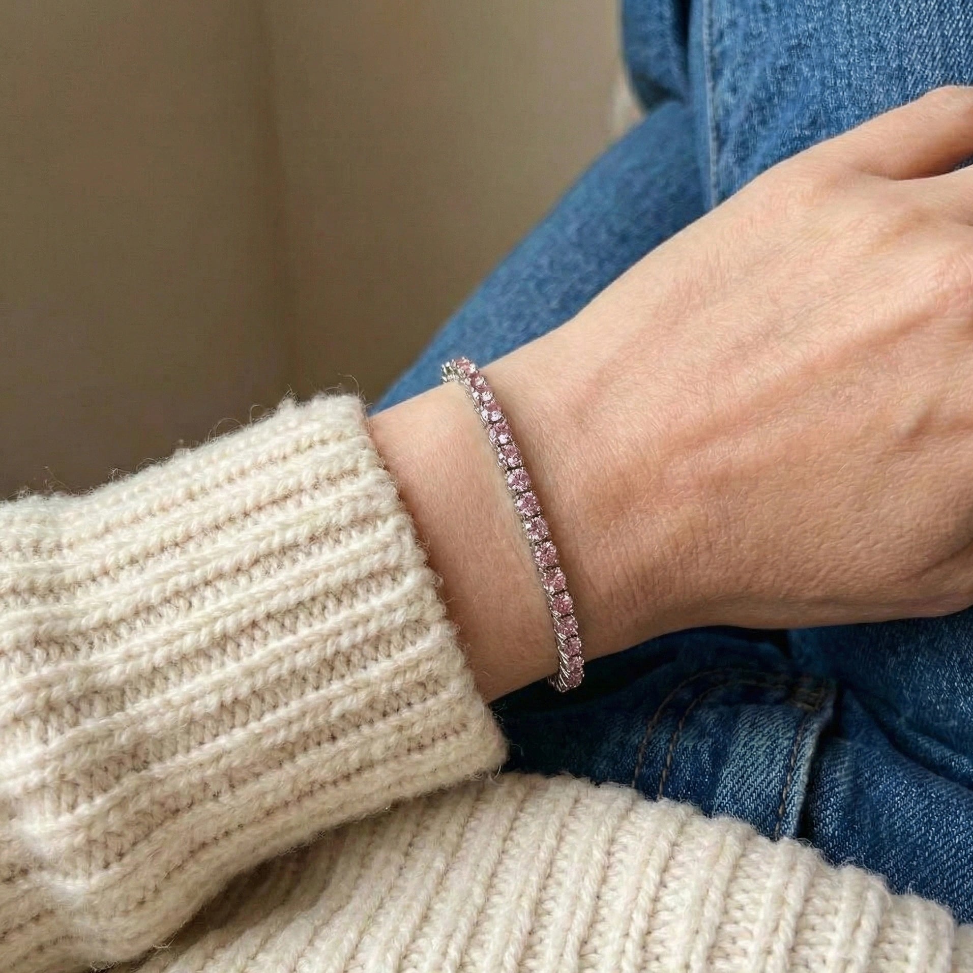 Pink moissanite tennis bracelet with rare brilliance worn casually with cream knit sweater and denim, showcasing refined everyday elegance - Sensitive Stones