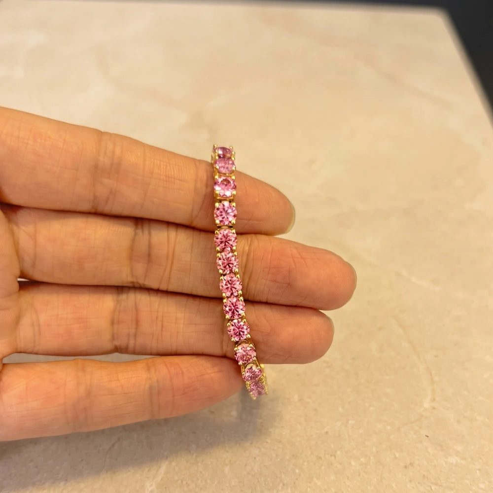 Pink moissanite tennis bracelet in 18K yellow gold plated sterling silver held in hand - Sensitive Stones