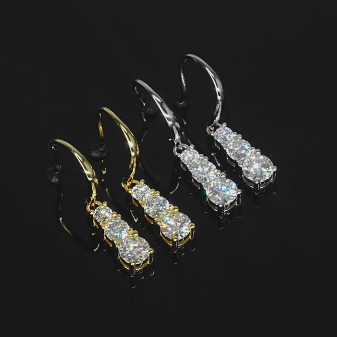 Video of moissanite three-stone dangle earrings sparkling from all angles in gold and silver finish - Sensitive Stones